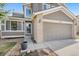 Home with a tan exterior, brick accents, attached garage, and walkway to a glass front door at 6725 Lionshead Pkwy, Lone Tree, CO 80124