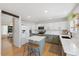 Kitchen with white cabinetry, hardwood floors, stainless steel appliances, and an island with seating at 6725 Lionshead Pkwy, Lone Tree, CO 80124