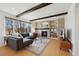 Bright living room with large window, wood beam ceiling, stone fireplace, and hardwood floors at 6725 Lionshead Pkwy, Lone Tree, CO 80124