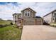 Charming two-story home with a three-car garage and well-manicured lawn and blue sky at 1076 Switch Grass Dr, Castle Rock, CO 80109