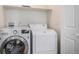 Bright laundry room with front loading washer and dryer and a shelf at 1076 Switch Grass Dr, Castle Rock, CO 80109