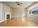 Open-concept living room featuring hardwood floors, fireplace, and large window at 17118 Knollside Ave, Parker, CO 80134