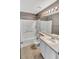 Bright bathroom featuring a tub with tile surround and a vanity with white cabinet and a light beige countertop at 5747 E Monument Dr, Castle Rock, CO 80104