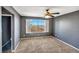 A serene bedroom featuring neutral carpet, gray walls, and a sunlit window at 5747 E Monument Dr, Castle Rock, CO 80104