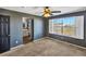 A cozy bedroom boasting a ceiling fan, gray walls, and a view into the adjacent bathroom at 5747 E Monument Dr, Castle Rock, CO 80104