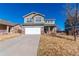 Charming two-story home with a well-manicured lawn, attached garage, and inviting curb appeal at 5747 E Monument Dr, Castle Rock, CO 80104