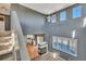 Open living room featuring high ceilings, large windows with shutter blinds, and a cozy fireplace at 5747 E Monument Dr, Castle Rock, CO 80104