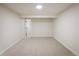 Large basement area featuring neutral carpeting and multiple access doors at 10792 Moore St, Broomfield, CO 80021