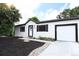 Newly remodeled exterior with white siding, black trim, a white door, and a well-maintained front yard at 10792 Moore St, Broomfield, CO 80021