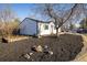 Street view of charming white single story home with dark trim, freshly mulched front yard at 10792 Moore St, Broomfield, CO 80021