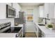 Modern kitchen features white cabinets, stainless steel appliances, and stylish countertops with sleek design at 10792 Moore St, Broomfield, CO 80021