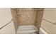 Close-up of a bathtub and toilet featuring tiled walls and chrome fixtures at 12170 Huron St # 106, Denver, CO 80234
