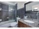 Modern bathroom featuring dark tile, glass shower enclosure, and granite-topped vanity at 38025 E 145Th Pl, Keenesburg, CO 80643