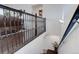 Elegant staircase with dark wood railing and decorative metal spindles leading to the lower level at 38025 E 145Th Pl, Keenesburg, CO 80643