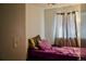 Bedroom featuring a bed with purple comforter, bright natural light, and carpeted floors at 1375 N Iola St, Aurora, CO 80010