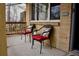 Charming front porch with two chairs with red cushions, a small table, and brick facade at 1375 N Iola St, Aurora, CO 80010