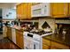 Traditional kitchen with wooden cabinets, granite countertops, tile backsplash, and modern white appliances at 1375 N Iola St, Aurora, CO 80010