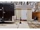 Tan storage shed with white door on concrete pad, next to black trailer at 1375 N Iola St, Aurora, CO 80010