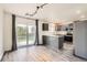 Eat-in kitchen with gray cabinets, stainless appliances, and a sliding glass door to the yard at 12507 Dexter Way, Thornton, CO 80241