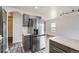 Bright kitchen with stainless steel refrigerator and gray wood floors at 12507 Dexter Way, Thornton, CO 80241