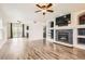 Open-concept living room with modern fireplace, built-in shelving, and wood-look floors at 12507 Dexter Way, Thornton, CO 80241