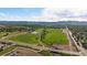 Scenic aerial view showcasing athletic fields, a pond, a road with a bridge and a parking lot with cars at 10321 W 59Th Ave # 2, Arvada, CO 80004