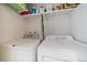 Efficient laundry area featuring a side-by-side washer and dryer, and practical shelving for storage at 10321 W 59Th Ave # 2, Arvada, CO 80004