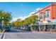 Lively street view showcasing the local shops, businesses, and mature trees, highlighting the area's vibrant charm at 10321 W 59Th Ave # 2, Arvada, CO 80004