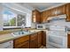 Efficient kitchen with wood cabinetry and plenty of natural light, offering a cozy cooking space at 4020 E 94Th Ave # B, Thornton, CO 80229
