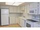 Well-lit kitchen featuring modern white cabinets, appliances, countertops, and tile flooring at 14390 E Marina Dr # 204, Aurora, CO 80014