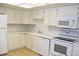 Well-lit kitchen featuring modern white cabinets, appliances, countertops, and tile flooring at 14390 E Marina Dr # 204, Aurora, CO 80014