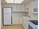 Well-lit kitchen featuring white cabinetry, countertops, appliances, and tan tile floors at 14390 E Marina Dr # 204, Aurora, CO 80014