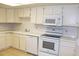 Well-lit kitchen featuring modern white cabinets, appliances, countertops, and tile flooring at 14390 E Marina Dr # 204, Aurora, CO 80014