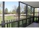Enclosed sunroom with metal railings and large windows showcasing a green lawn with mature trees beyond at 14390 E Marina Dr # 204, Aurora, CO 80014
