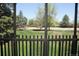 An enclosed sunroom with metal railings and large windows showcasing a green lawn and mature trees beyond at 14390 E Marina Dr # 204, Aurora, CO 80014