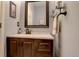 Well-lit powder room with a modern vanity, framed mirror, and convenient towel rack at 18605 E Saratoga Pl, Aurora, CO 80015