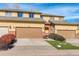 Inviting townhome featuring a two-car garage, a well-kept lawn, and sunny yellow siding at 18605 E Saratoga Pl, Aurora, CO 80015