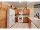 Well-lit kitchen with white appliances, wood cabinets, and tile backsplash at 18605 E Saratoga Pl, Aurora, CO 80015