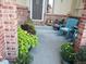 Inviting front porch featuring brick accents, stylish seating and a variety of plants at 18605 E Saratoga Pl, Aurora, CO 80015