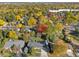 An aerial view of the neighborhood showcases mature trees in autumn colors and well-maintained homes at 2602 S Kearney St, Denver, CO 80222