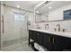 This bathroom features a double sink, tiled walls, walk-in shower, and modern fixtures at 2602 S Kearney St, Denver, CO 80222