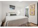 Cozy bedroom with a white bed, neutral tones, and a glimpse of the ensuite bathroom through an open doorway at 2602 S Kearney St, Denver, CO 80222