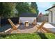 Backyard fire pit area with modern wooden chairs and a gravel base, ideal for cozy outdoor gatherings at 2602 S Kearney St, Denver, CO 80222