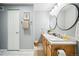 Bathroom with double vanity, modern faucets, round mirrors, and white marble floors at 444 17Th St # 807, Denver, CO 80202