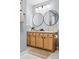 Bathroom with double vanity, modern faucets, round mirrors, and light grey painted walls at 444 17Th St # 807, Denver, CO 80202