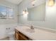 Traditional bathroom with a large vanity, window and toilet at 10636 Ura Ln, Northglenn, CO 80234