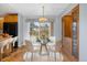 Cozy dining area features wood floors, chandelier, and a glass table with modern chairs at 10636 Ura Ln, Northglenn, CO 80234