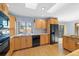 Bright kitchen featuring wooden cabinets, and a black dishwasher at 10636 Ura Ln, Northglenn, CO 80234