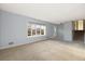 Bright living room featuring neutral carpet and large window allowing for ample natural light at 10636 Ura Ln, Northglenn, CO 80234