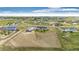 Expansive aerial view of a residential community, showcasing spacious lots and beautiful home exteriors under a bright, cloudy sky at 196 W 8Th Ave, Byers, CO 80103